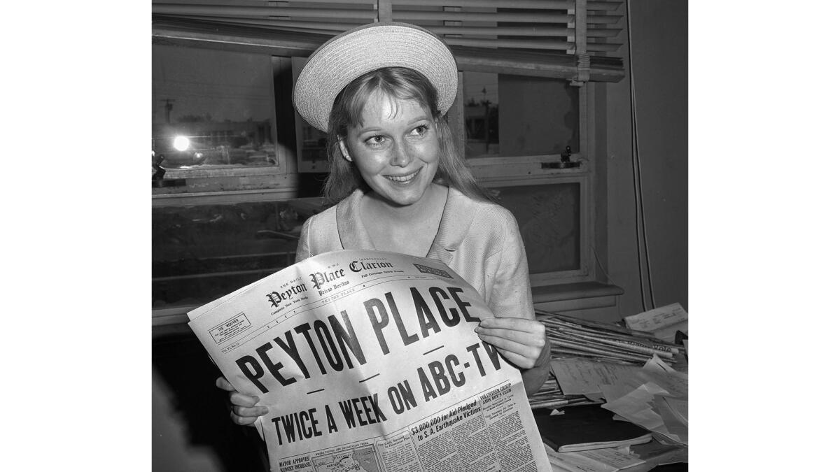 June 16, 1964: Mia Farrow poses at the Santa Monica Courthouse with a copy of the "Peyton Place Clarion."
