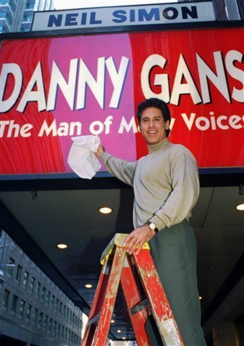 FILE - In this Sept. 27, 1995 file photo, Danny Gans dusts off the marquee of New York's Neil Simon Theater, which hosts his one-man show, "Danny Gans: The Man of Many Voices". An official at Wynn Las Vegas said Friday, May 1, 2009 performer Danny Gans is dead at 52. Hotel spokeswoman Jennifer Dunne says Gans died early Friday at home in Las Vegas. (AP Photo/Marty Reichenthal, file)