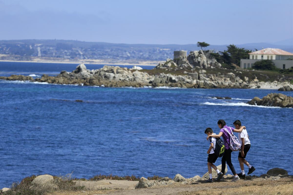 People walk on the shore at Monterey Bay