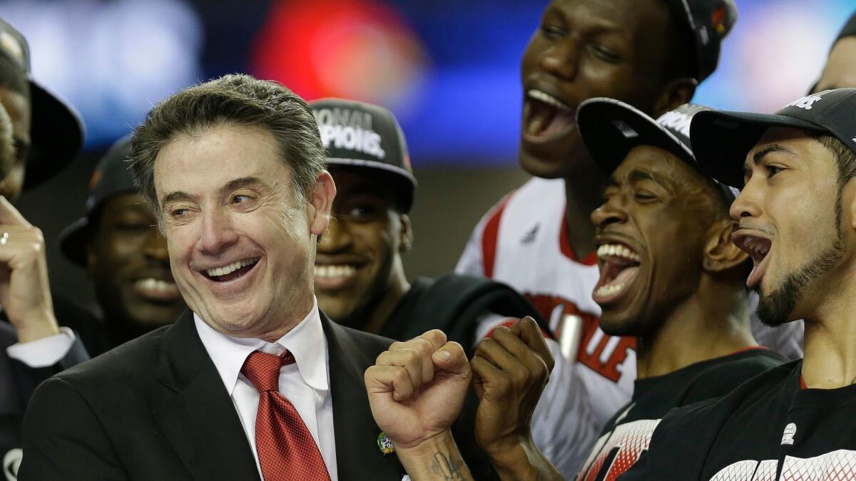 Then-coach Rick Pitino celebrates with his players after Louisville defeated Michigan in the 2013 NCAA championship game.