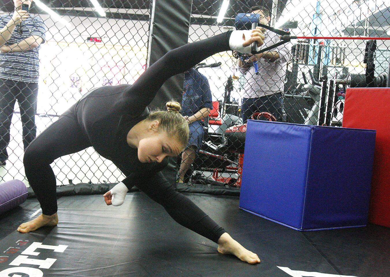 Ronda Rousey stretches with a bungee at an open workout with the MMA champion at the Glendale Fighting Club in Glendale on Monday, February 10, 2014. Several media photographers and reporters documented Rousey's every move as she gave interviews, warmed up, and sparred with her trainer Edmund Tarverdyan.