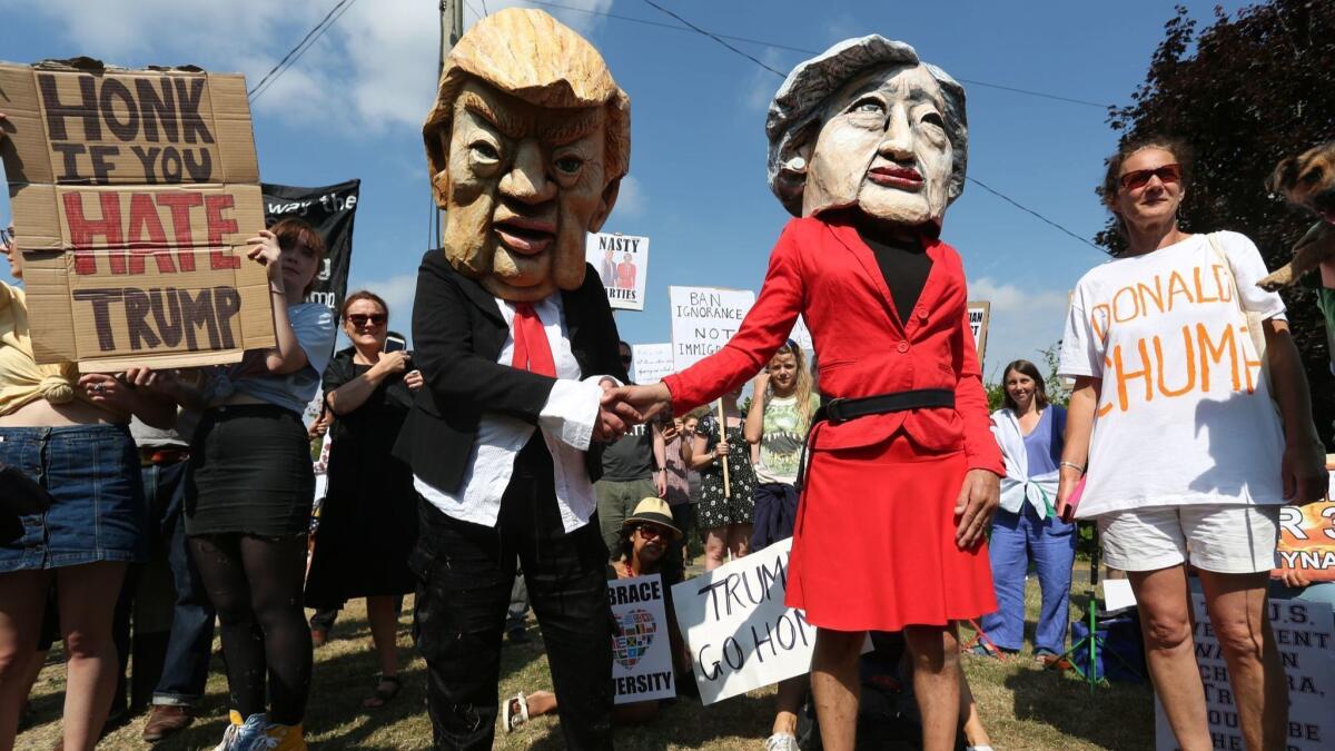 Protesters wearing masks depicting President Trump and Britain's Prime Minister Theresa May join others outside Chequers, the prime minister's country residence, where the two met on Friday.