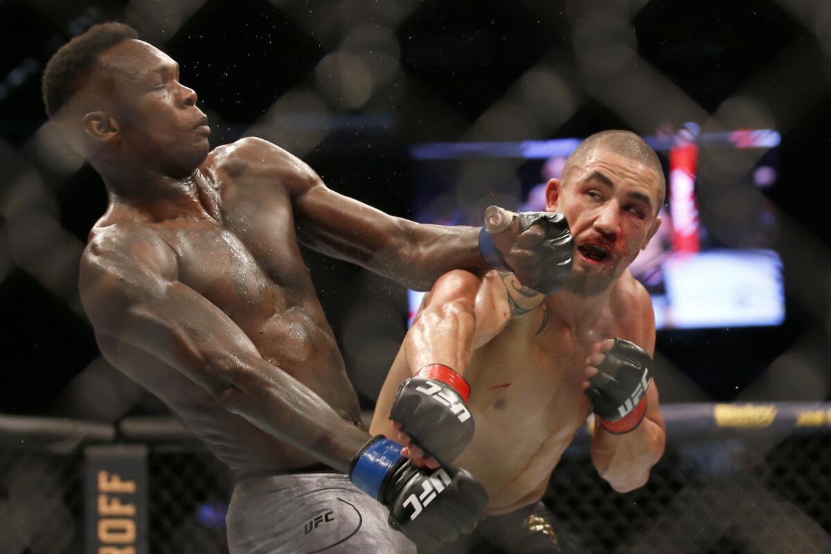 Israel Adesanya, left, punches Robert Whittaker during UFC 243 earlier this month.