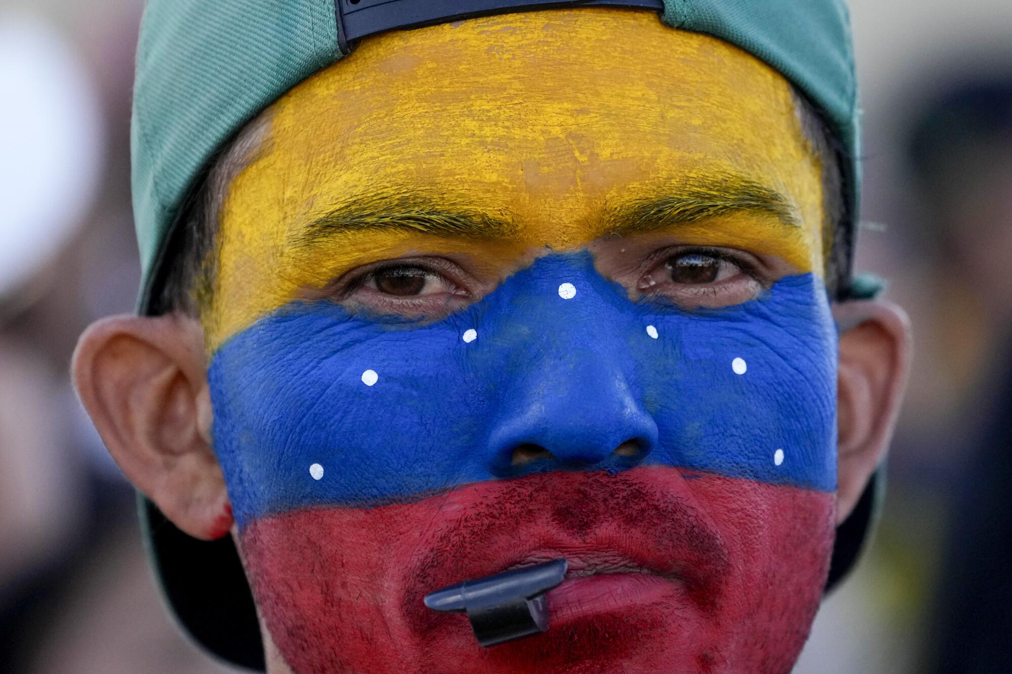 Un venezolano residente en Brasilia, Brasil, con el rostro pintado con los colores 