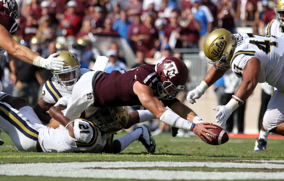 Texas A&M quarterback Trevor Knight dives over the goal line for a touchdown as UCLA defensive back Tahaan Goodman (21) attempts to tackle him during a game in College Station, Texas, last season.