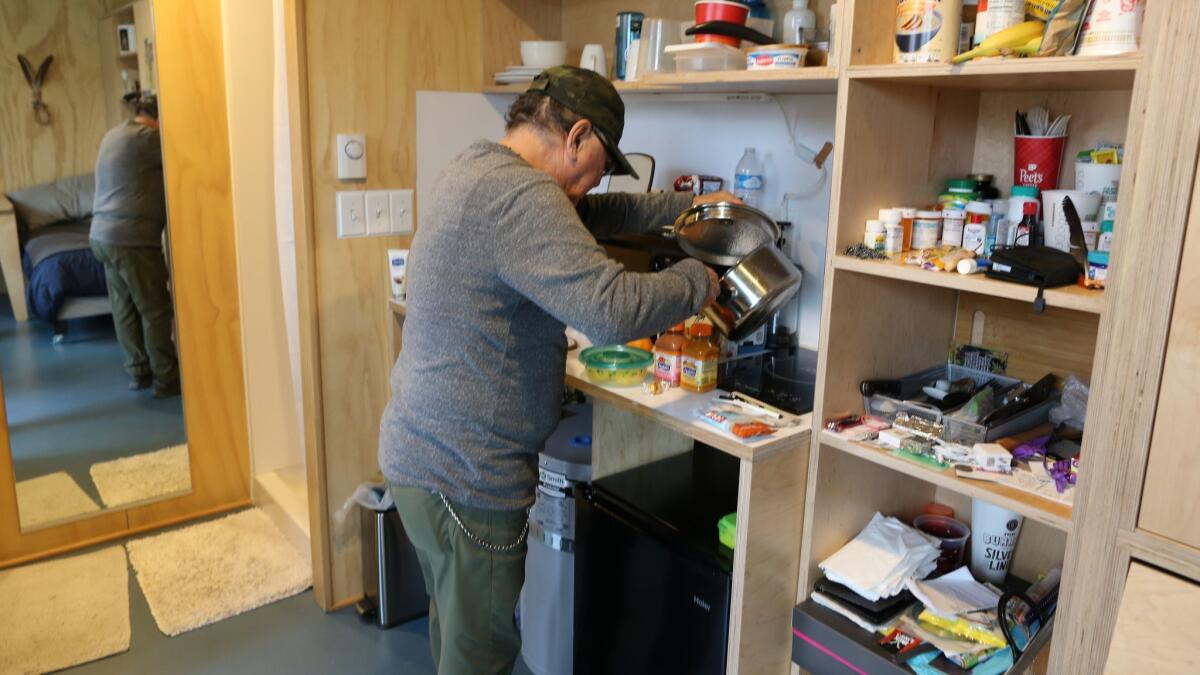 Robert Desjarlais makes tea in his 125-square-foot house in Seattle.