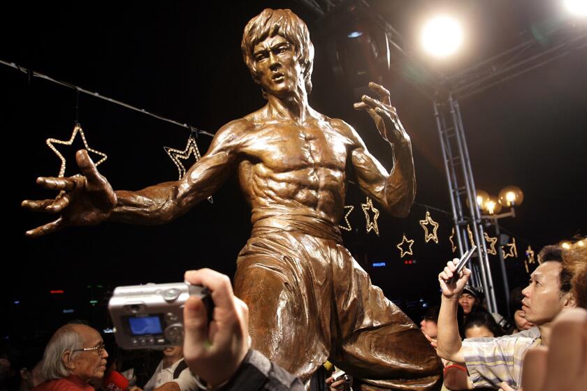 Fans take pictures of the statue of late martial arts legend Bruce Lee in Hong Kong