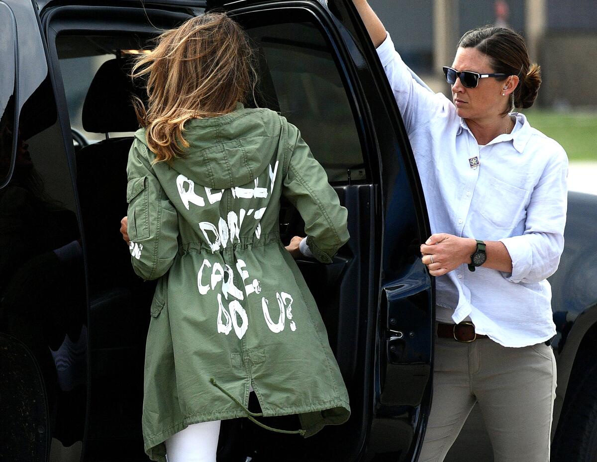 Melania Trump, wears jacket with 'I really don't care, do u?' on the back; climbs into vehicle as person holds door for her.