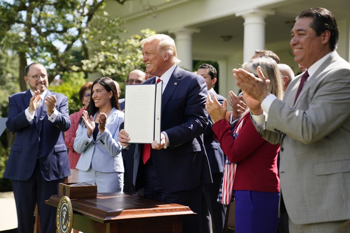 President Donald Trump holds an executive order on the "White House Hispanic Prosperity Initiative," after signing it in the Rose Garden of the White House, Thursday, July 9, 2020, in Washington. (AP Photo/Evan Vucci)