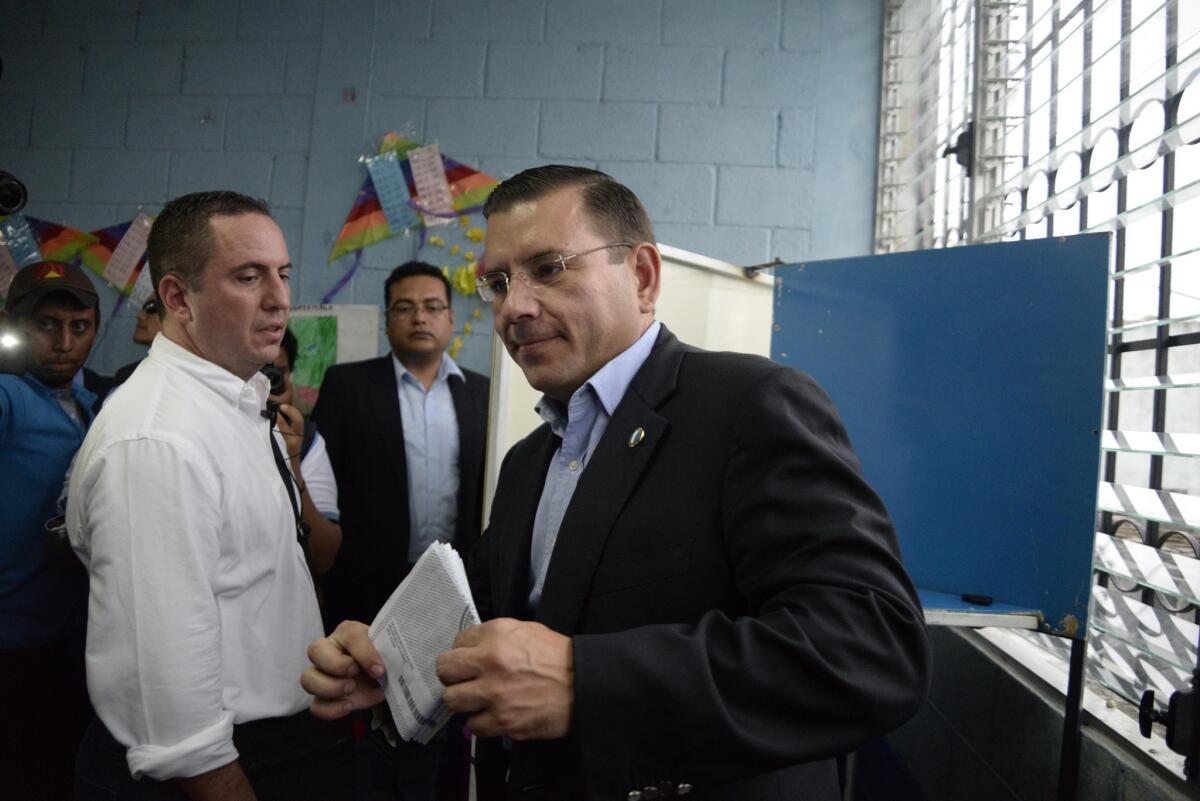 Manuel Baldizon, right, who Monday dropped out of the presidential race in Guatemala, is seen at a polling place in Peten, north of Guatemala City, during general elections Sept. 6.