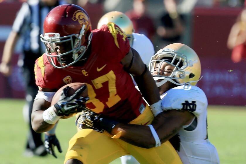 USC running back Javorius Allen is brought down by Notre Dame safety Elijah Shumate during the second quarter of the Trojans' 49-14 win over Notre Dame on Nov. 29 at the Coliseum.