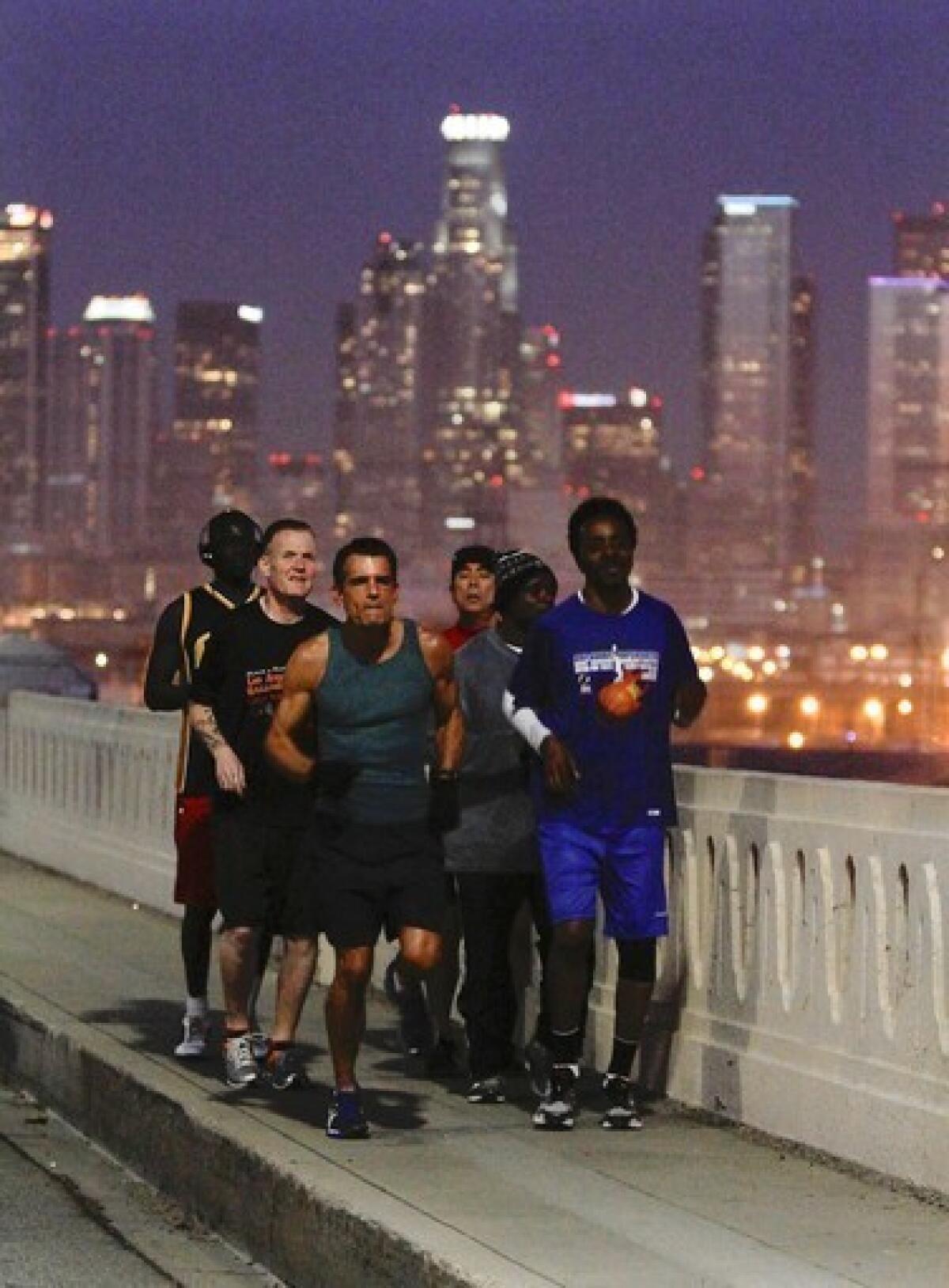 L.A. County Superior Court Judge Craig Mitchell, center, leads a group of Midnight Mission residents on an early morning run across the 6th Street bridge.