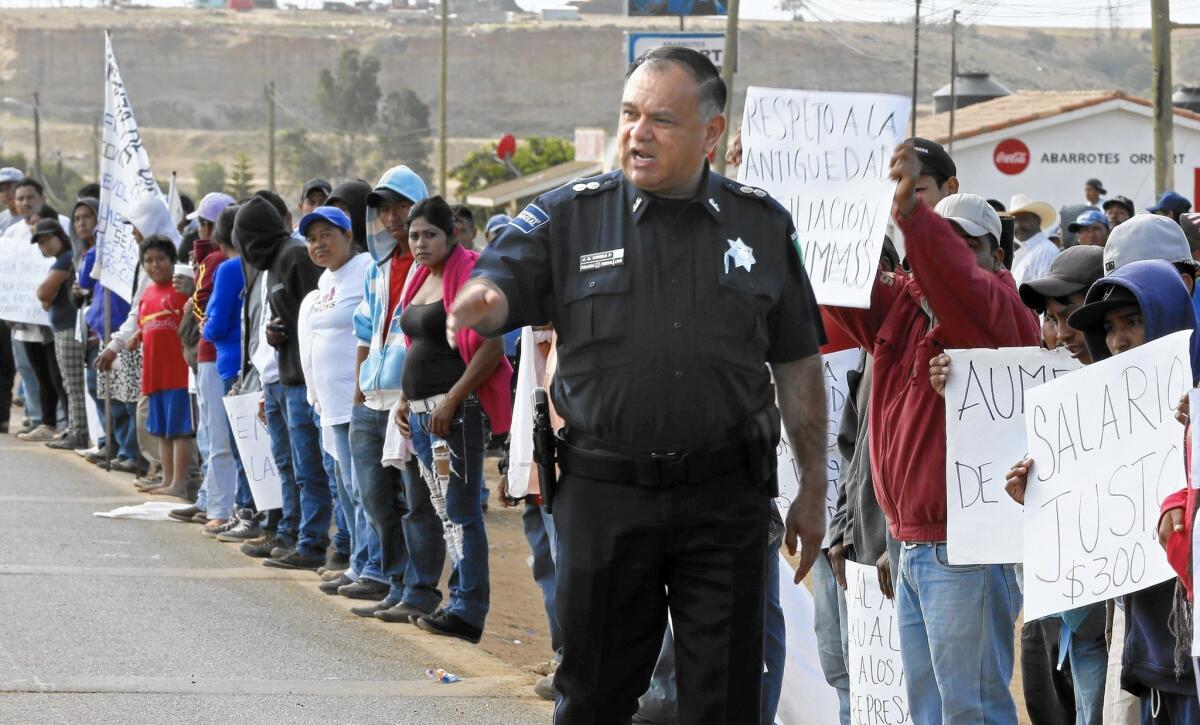A Mexican police officer orders striking farmworkers to stay off the Transpeninsular Highway.