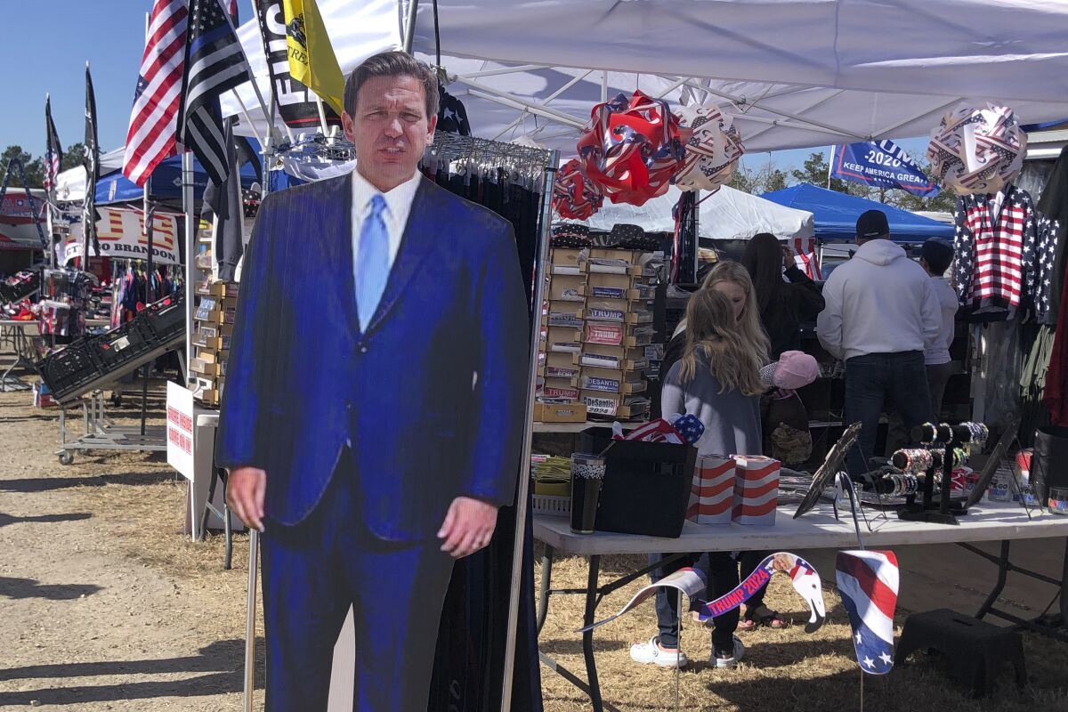 A cardboard cutout of Florida Gov. Ron DeSantis stands in the merchandise area outside former President Donald Trump's rally in Conroe, Texas, Saturday, Jan. 29, 2022. At Trump’s rally, there were signs of change. Next to the Trump hats, shirts and flags sat a collection of Ron “DeSantis 2024” bumper stickers. The vast majority of those interviewed at Trump’s rally enthusiastically cheered the prospect of another Trump run. But there were some who conceded that, perhaps, there might be a better option. (AP Photo/Jill Colvin)