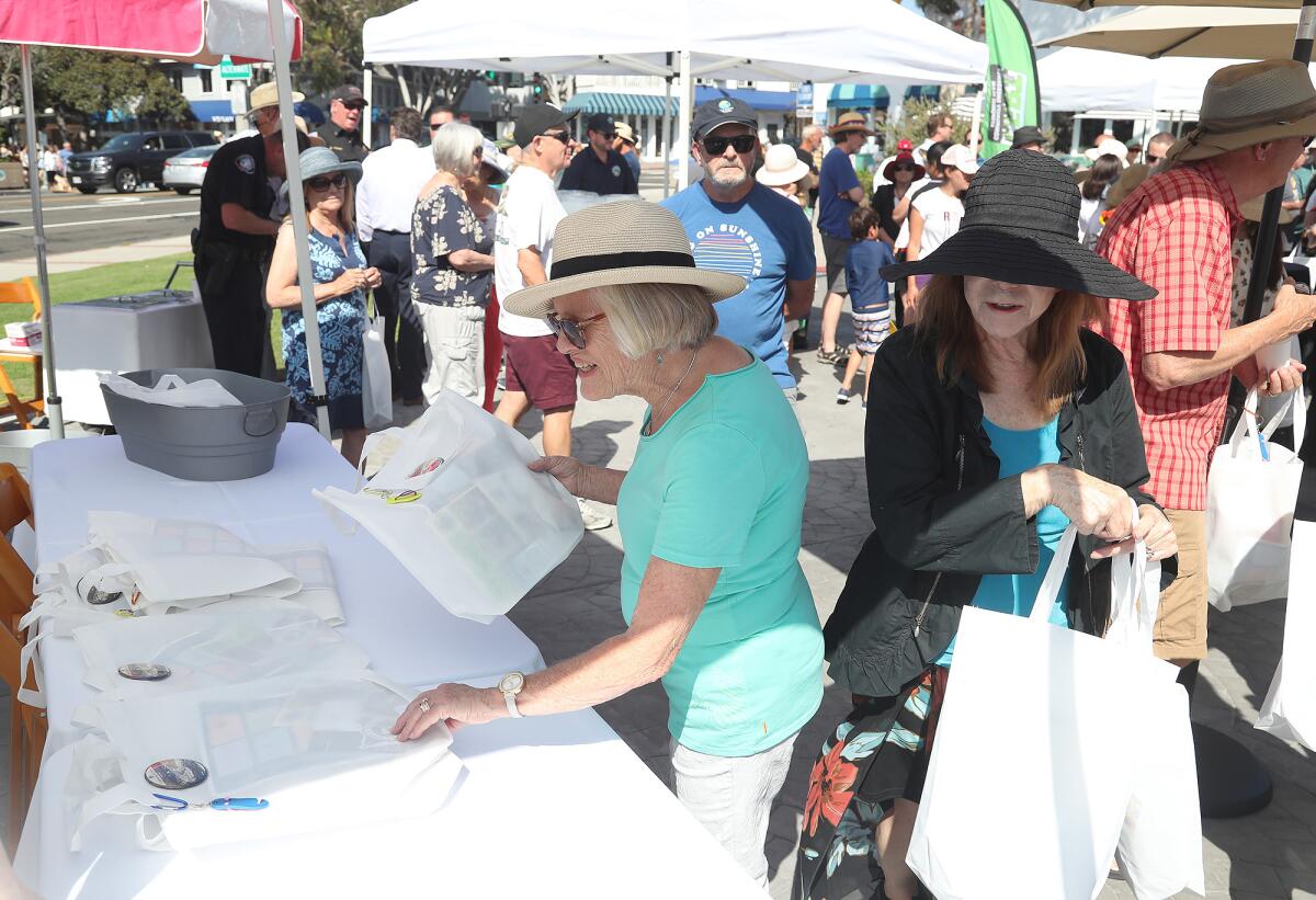 Guests grab gift bags, compliments of the city, during the 95th birthday celebration for Laguna Beach.