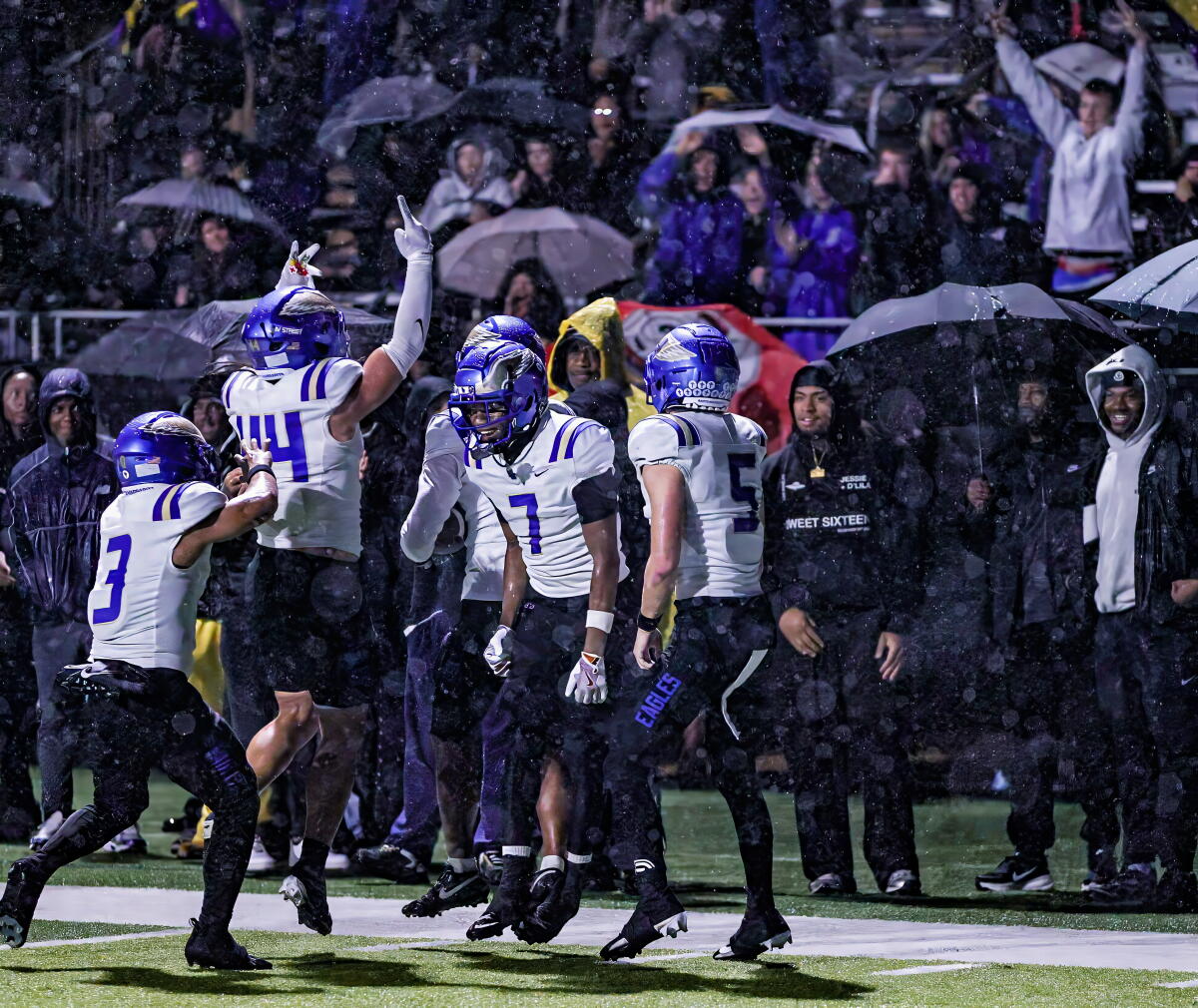 Santa Margarita defensive players celebrate interception by Siua Holani (14) in second quarter against Sierra Canyon.