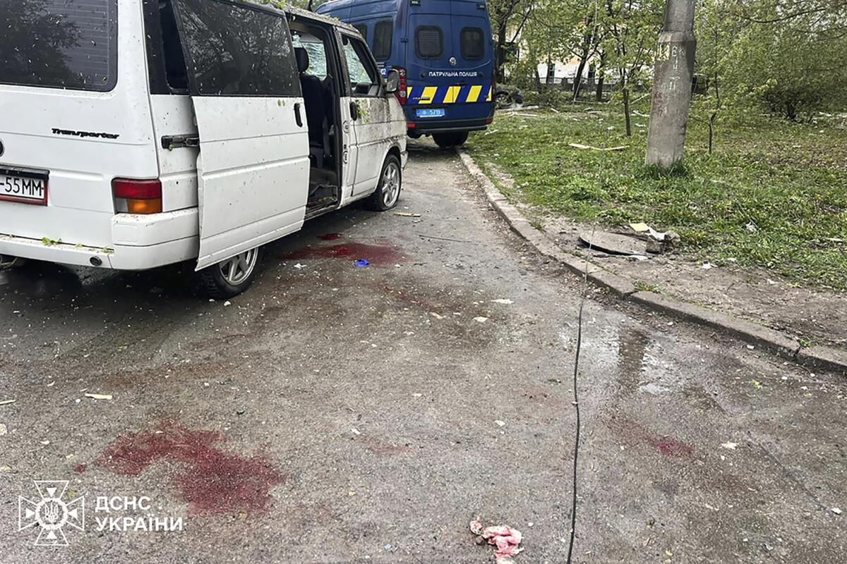 Blood is seen on the street next to a car damaged by Russian missile strike in Chernihiv, Ukraine.
