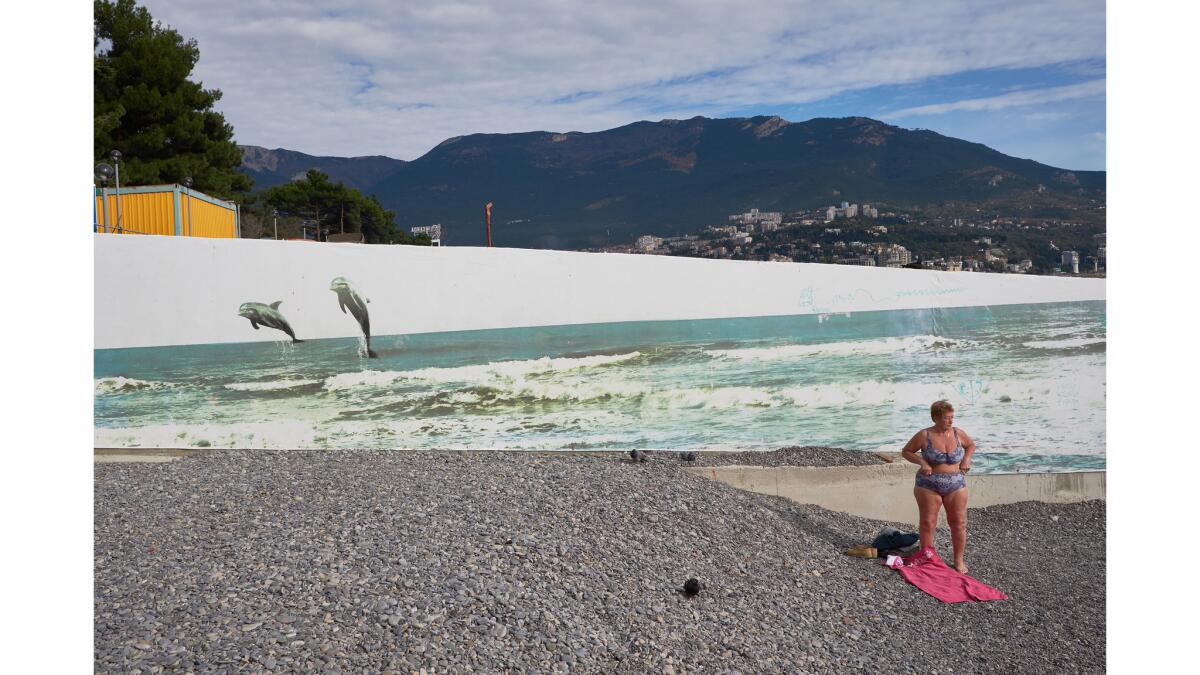 The tourism industry on the Crimean peninsula has suffered since Russian annexation as investors flee, fearing Western sanctions. Above, a pensioner sunbathes in Yalta.