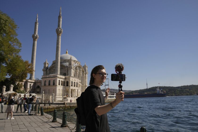 El bloguero ruso Niki Proshin filma un video para su canal de YouTube frente a la mezquita Ortakoy de Estambul el 30 de septiembre del 2022. Proshin se fue de Rusia porque no quiere ser reclutado por el ejército para pelear en Ucrania. (AP Photo/Khalil Hamra)