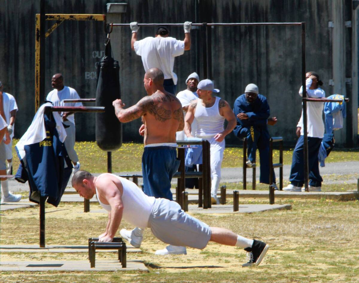 Inmates exercise in the general population yard at Pelican Bay State Prison. California prison population reports show crowding has fallen below a court-ordered cap for the first time.