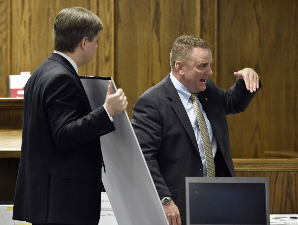 Erath County Dist. Atty. Alan Nash, left, holds evidence as forensics expert Howard J. Ryan testifies during the murder trial of former Marine Cpl. Eddie Ray Routh in Stephenville, Texas.