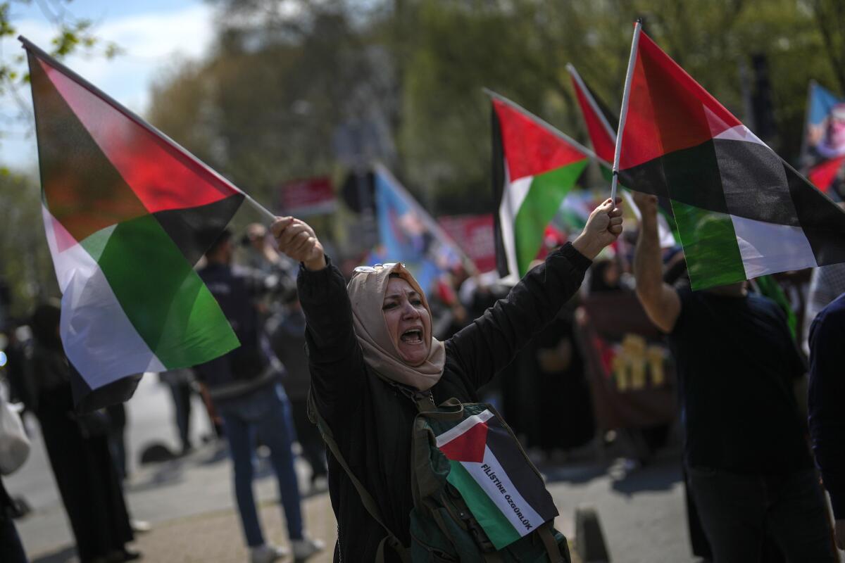 Una mujer ondea banderas en apoyo a los palestinos en la Franja de Gaza durante una protesta, el viernes 5 de abril de 2024, en Estambul. (AP Foto/Khalil Hamra, Archivo)