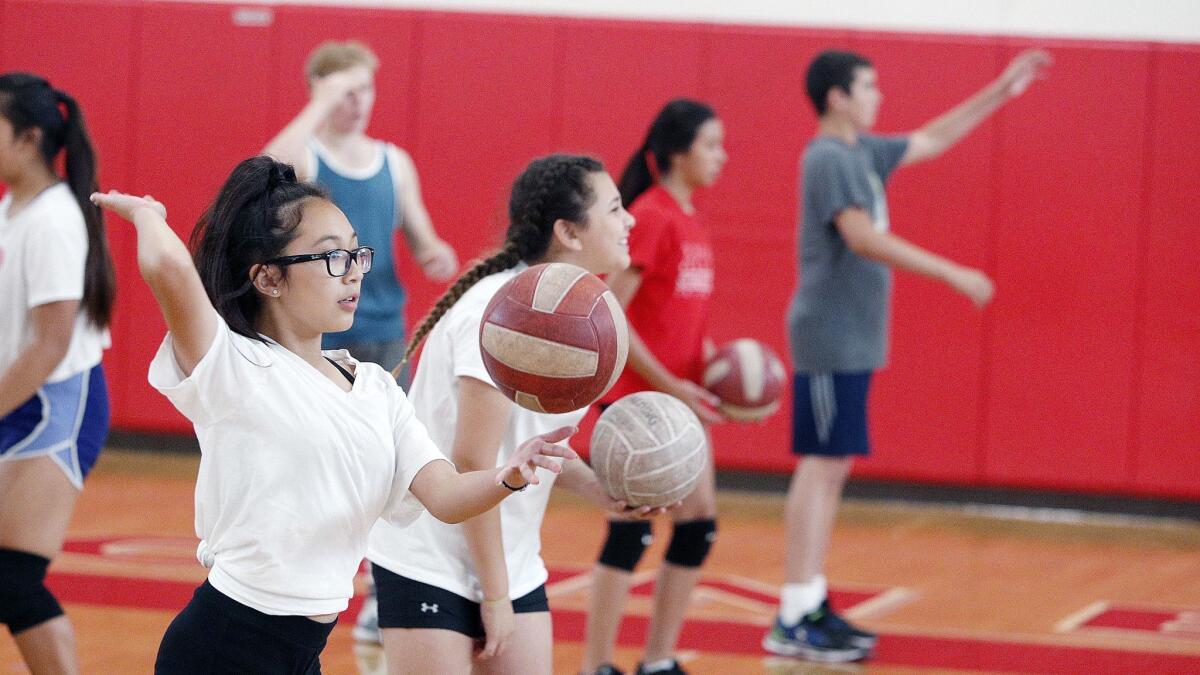 Anika Montes, of Burbank, tosses up the ball to practice a kill during a drill at Real's Youth Volleyball Camps at Burroughs High School on June 4, 2018. Though healthier than their state counterparts, Burbank Unified students generally aren’t as fit as they were a few years back
