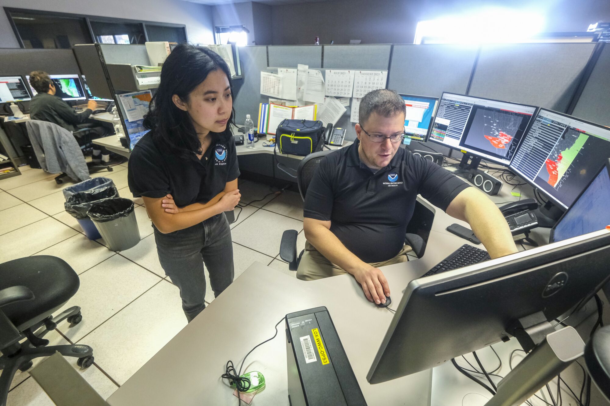 National Weather Service meteorologist Rose Schoenfeld, left, talks with Meteorologist In Charge, Dr. Ariel Cohen 