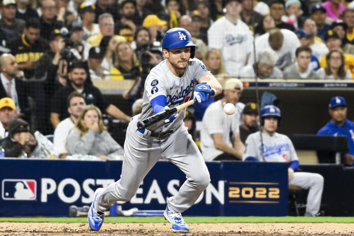 Dodgers' Trea Turner bunts for a single during the seventh inning in Game 4 of the NLDS against the San Diego Padres.