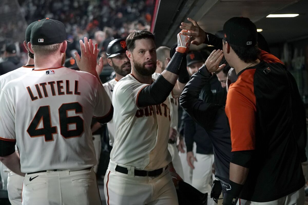 San Francisco Giants' Brandon Belt, middle, is congratulated by teammates after hitting a two-run home run against the San Diego Padres during the fourth inning of a baseball game in San Francisco, Monday, Sept. 13, 2021. (AP Photo/Jeff Chiu)