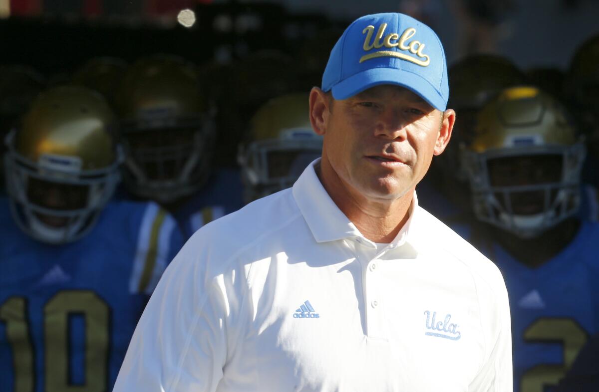 UCLA coach Jim Mora leads his players on to the field before a game against Nevada Las Vegas.