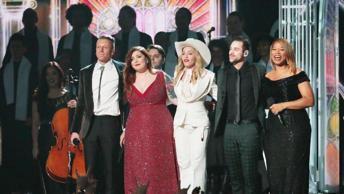 Couples are wed as Macklemore, left, performs with Mary Lambert, Madonna, Ryan Lewis and Queen Latifah at the 56th Grammy Awards.