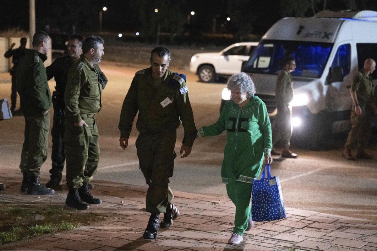 Ruth Munder, una rehén israelí liberada, camina junto a un soldado israelí