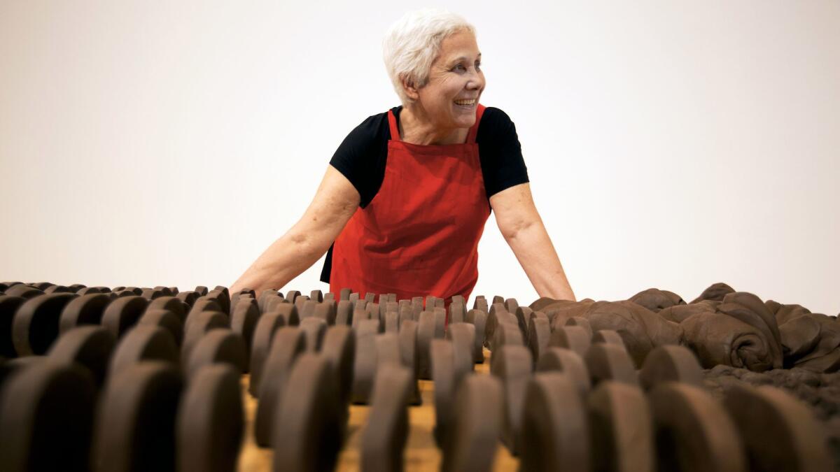 Anna Maria Maiolino stands before unfired clay objects that are part of her MOCA retrospective.