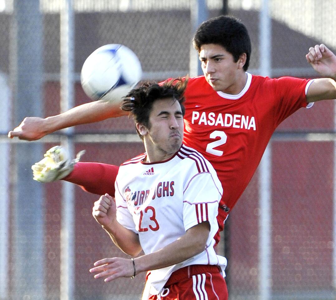 Pasadena's Alejandro Loeza high kicks to clear the ball passed the attack of Burroughs' Brandon Gerlach in the second half in a Pacific League boys soccer match at Burroughs High School in Burbank on Monday, January 28, 2013. Pasadena won the match 3-1.