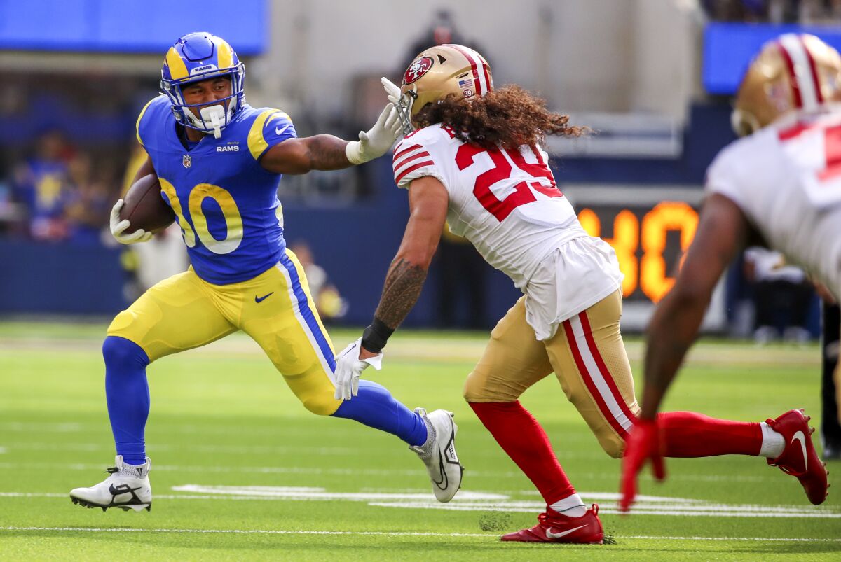 Rams running back Ronnie Rivers gives 49ers safety Talanoa Hufanga a straight arm.