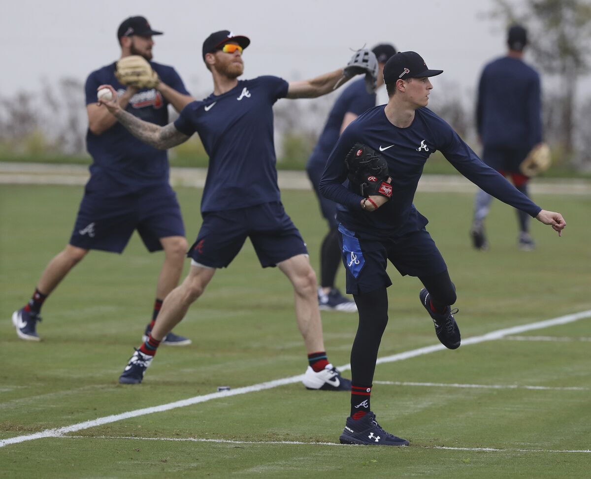 Atlanta Braves pitchers, from left, Shane Greene, Mike Foltynewicz and Max Fried loosen up at spring training baseball camp in North Port, Fla., Wednesday, Feb. 12, 2020. (Curtis Compton/Atlanta Journal-Constitution via AP)