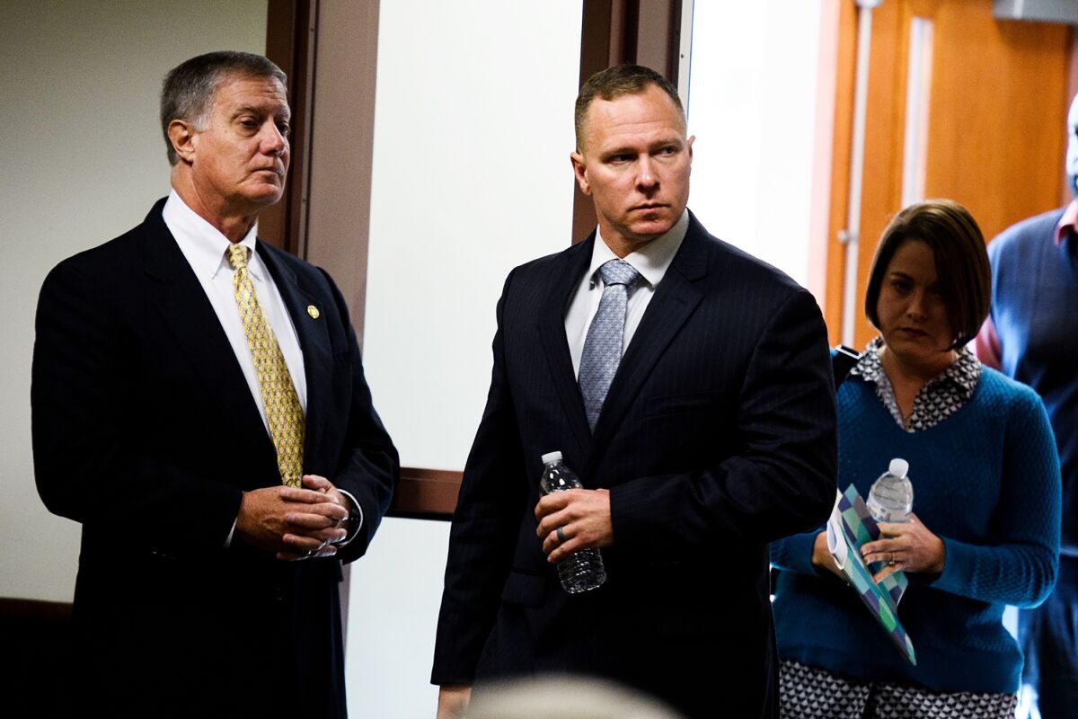 FILE - In this Oct. 24, 2019, file photo, suspended Greenville Sheriff Will Lewis, center, enters the courtroom with his wife, Amy, in Greenville, S.C. The former sheriff in South Carolina reported to prison Wednesday, Oct. 13, 2021, to serve a one-year sentence for using his power and office to pressure a personal assistant to have sex with him. The South Carolina Supreme Court refused to reconsider its August decision upholding ex-Greenville County Sheriff Will Lewis' 2019 conviction meaning Lewis ran out of appeals. (Josh Morgan/The Greenville News via AP, Pool, File)