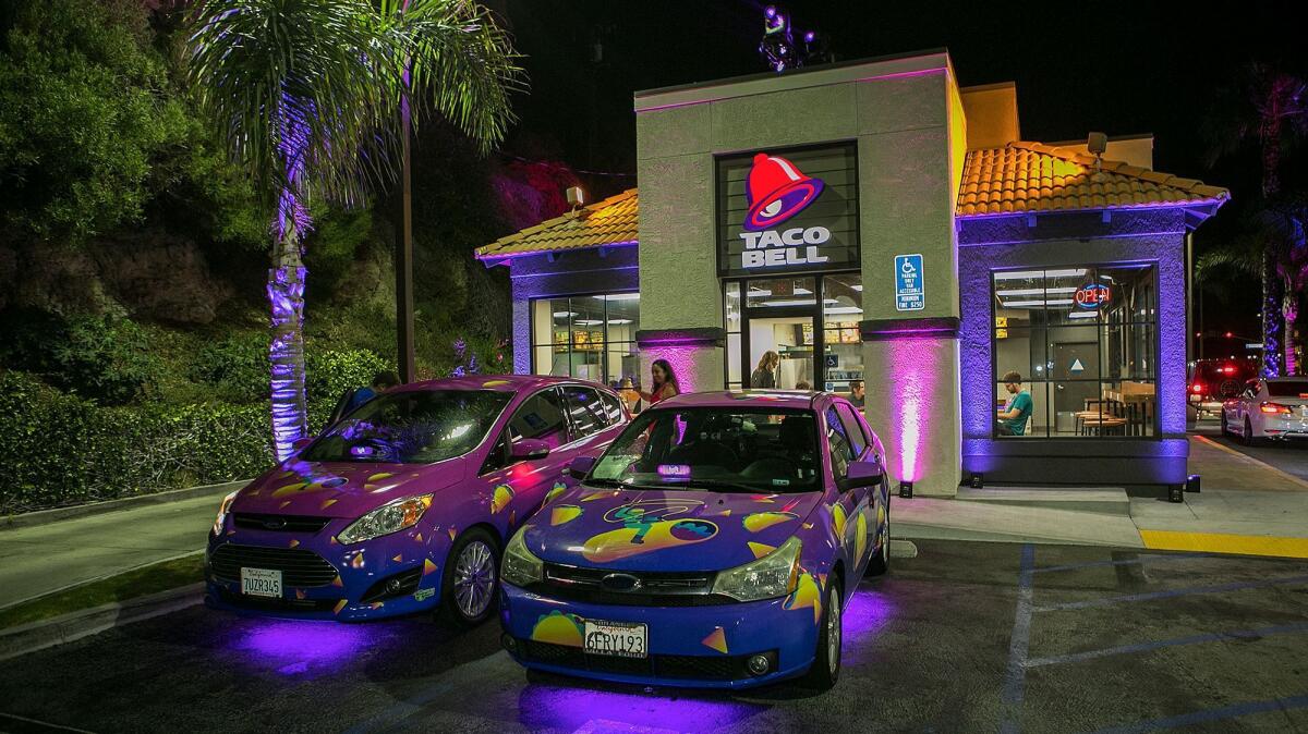 Taco Bell-branded Lyft cars park outside the restaurant on West Coast Highway in Newport Beach on July 27.
