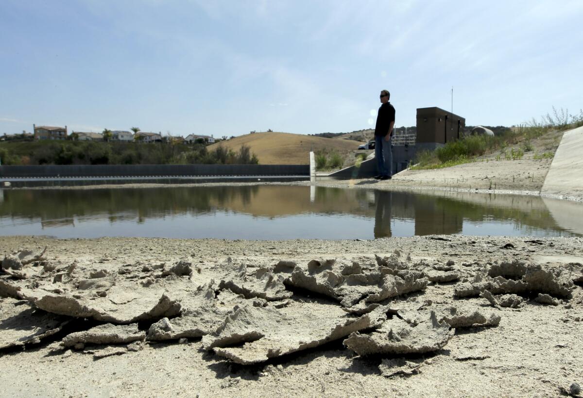 Rich Kissee, operations manager for the Santa Margarita Water District, stands on the edge of a water runoff reservoir in Rancho Santa Margarita, Calif., on July 2.