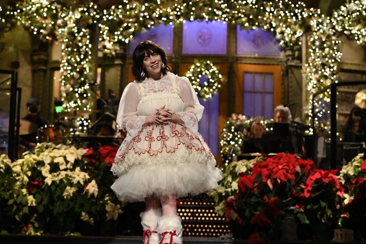 A woman wearing a white, ruffled dress on a festive stage