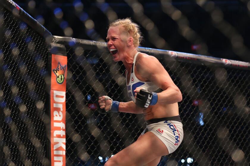 Holly Holm celebrates her victory over Ronda Rousey in their women's bantamweight championship bout at UFC 193 event in Melbourne, Australia.