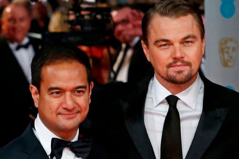 (FILES) In this file photo taken on February 16, 2014, US producers Riza Aziz (L) with US actor Leonardo DiCaprio (C) arrive on the red carpet for the BAFTA British Academy Film Awards at the Royal Opera House in London. - The Malaysian producer of the Leonardo DiCaprio-starred film "The Wolf of Wall Street" was arrested on July 4, 2019 on suspicion of money laundering as part of investigations into the 1MDB scandal, officials said. (Photo by ANDREW COWIE / AFP)ANDREW COWIE/AFP/Getty Images ** OUTS - ELSENT, FPG, CM - OUTS * NM, PH, VA if sourced by CT, LA or MoD **