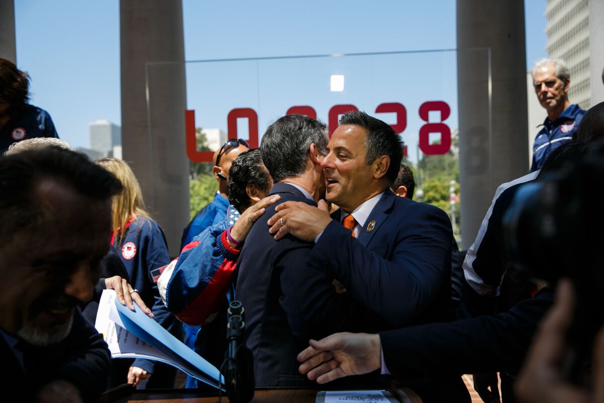 Mayor Eric Garcetti is congratulated by council member Joe Buscaino at a news conference to announce the vote city's approval of a deal to host the 2028 Olympics.