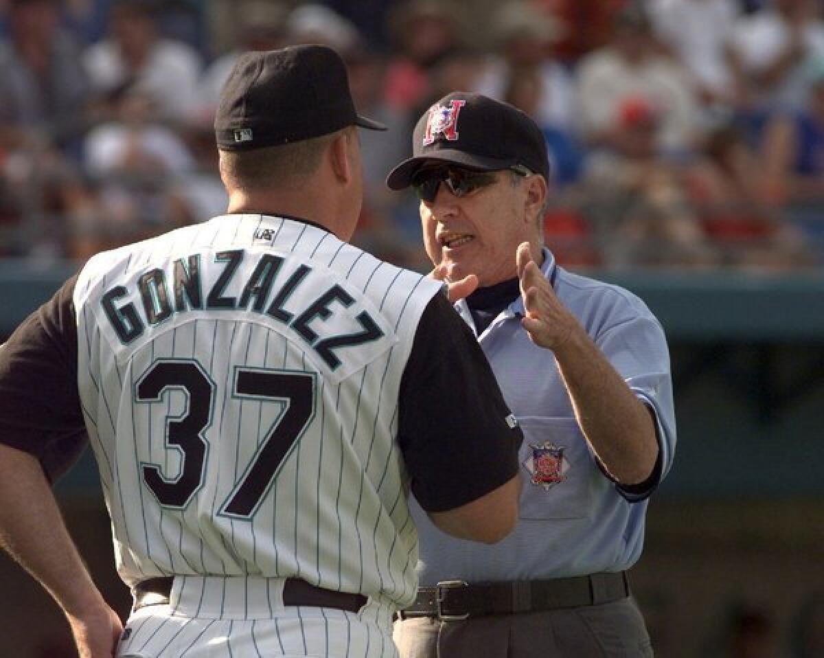 In this May 31, 1999, file photo, Florida Marlins manager Freddi Gonzalez, left, listens to third base umpire Frank Pulli during the fifth inning of a baseball game against the St. Louis Cardinals in Miami. Pulli used instant TV replay to retract a home run call.