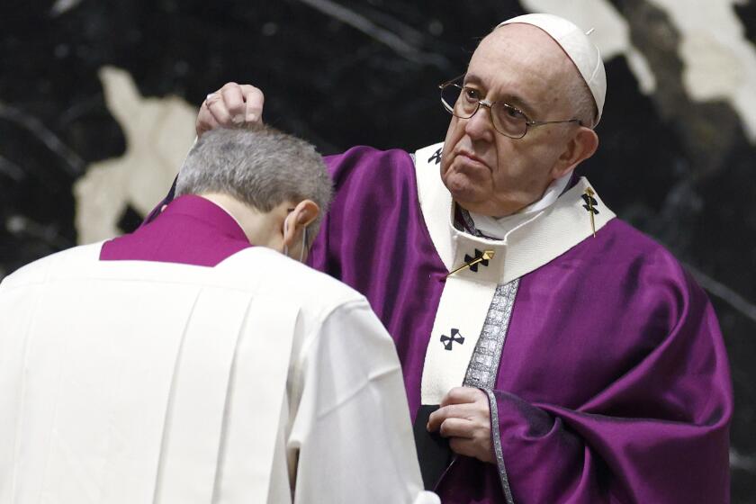 Pope Francis sprinkles a member of the clergy with ashes during the Ash Wednesday mass leading Catholics into Lent, at St. Peter's Basilica at the Vatican, Wednesday, Feb. 17, 2021. (Guglielmo Mangiapane/Pool photo via AP)