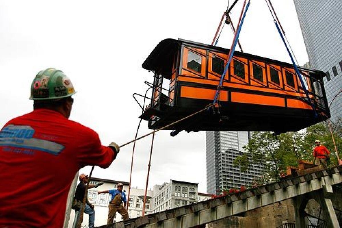 Workers lower an Angels Flight rail car onto the tracks in downtown Los Angeles. The railway that takes passengers to the top of Bunker Hill has been closed since a fatal accident in 2001 but could reopen as early as the end of the year. More photos >>>