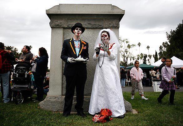 Grant and Leanna Matthews adjust their skeleton outfits after the couple had lunch by a tombstone at Hollywood Forever Cemetery on Saturday. The celebration at the Hollywood cemetery was a mixture of Mexican traditions and Hollywood hip.