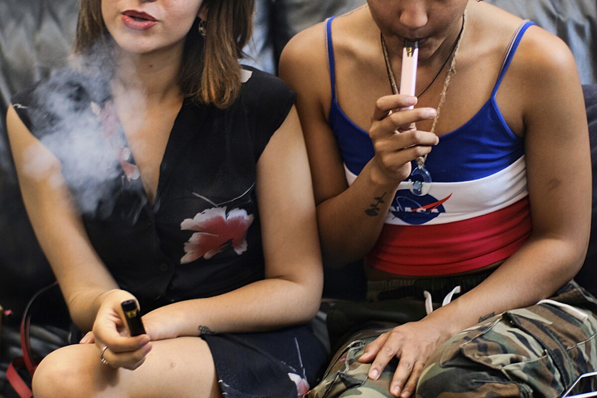 People smoke cannabis vape pens at a party in Los Angeles. 