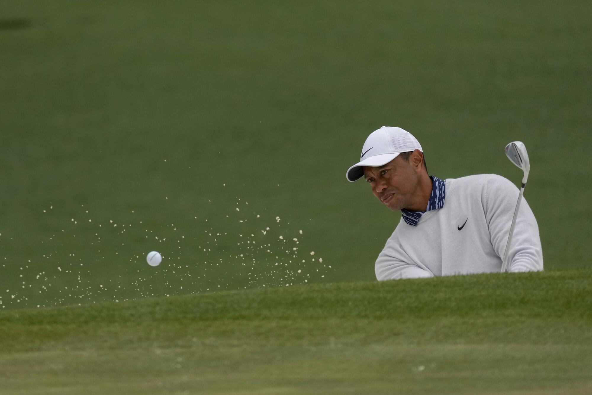 Tiger Woods hits out of a bunker on the second hole during the third round.